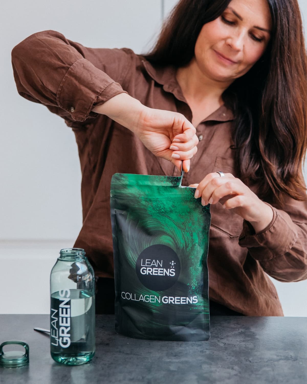 Woman preparing Collagen Greens morning drink – part of her daily wellness routine